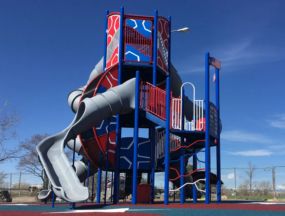 Red, white and blue three level playground with rubber matting at Veteran's Park
